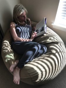 A woman sitting on top of a bean bag chair.